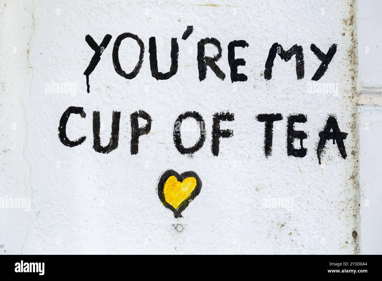 Vecchio frammento di parete in cemento, sfondo con texture in stucco dipinta con una scritta You're My Cup of Tea Foto Stock