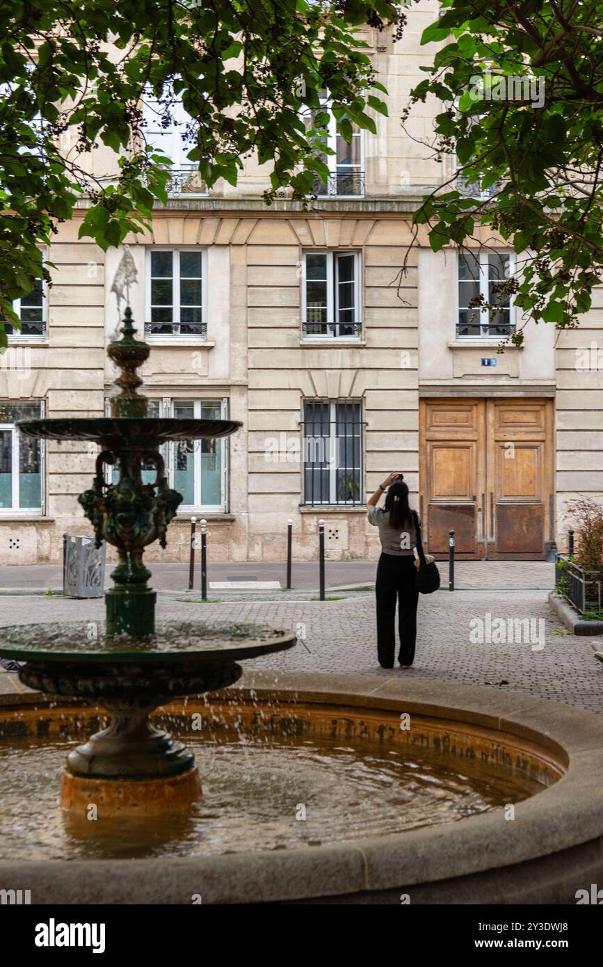 Una donna fotografa un edificio a Place de l'Estrapade, dove ha girato l'appartamento di Emily nella serie di Netflix "Emily in Paris". Foto Stock