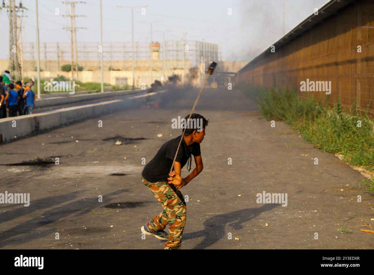 I manifestanti palestinesi si scontrano con le forze di sicurezza israeliane al valico di frontiera di Erez nella Striscia di Gaza settentrionale il 3 ottobre 2018. Secondo il Ministero della salute di Gaza, un palestinese di 15 anni, Ahmad Samir Abu Habell, è stato ucciso alla testa da un soldato israeliano durante gli scontri lungo la recinzione di confine nella parte settentrionale di Gaza mercoledì. Secondo le stesse fonti, anche quindici palestinesi sono stati feriti a causa di incendi vivi e inalazioni di gas lacrimogeni subite durante gli scontri. Un certo numero di paramedici hanno partecipato al luogo di protesta per assistere i feriti. I palestinesi hanno protestato contro la durata di 11 anni Foto Stock