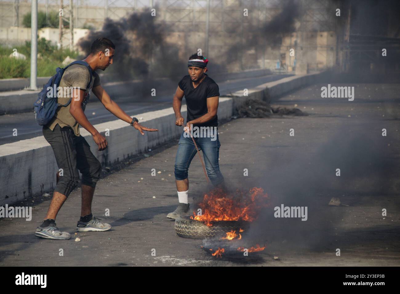 I manifestanti palestinesi si scontrano con le forze di sicurezza israeliane al valico di frontiera di Erez nella Striscia di Gaza settentrionale il 3 ottobre 2018. Secondo il Ministero della salute di Gaza, un palestinese di 15 anni, Ahmad Samir Abu Habell, è stato ucciso alla testa da un soldato israeliano durante gli scontri lungo la recinzione di confine nella parte settentrionale di Gaza mercoledì. Secondo le stesse fonti, anche quindici palestinesi sono stati feriti a causa di incendi vivi e inalazioni di gas lacrimogeni subite durante gli scontri. Un certo numero di paramedici hanno partecipato al luogo di protesta per assistere i feriti. I palestinesi hanno protestato contro la durata di 11 anni Foto Stock