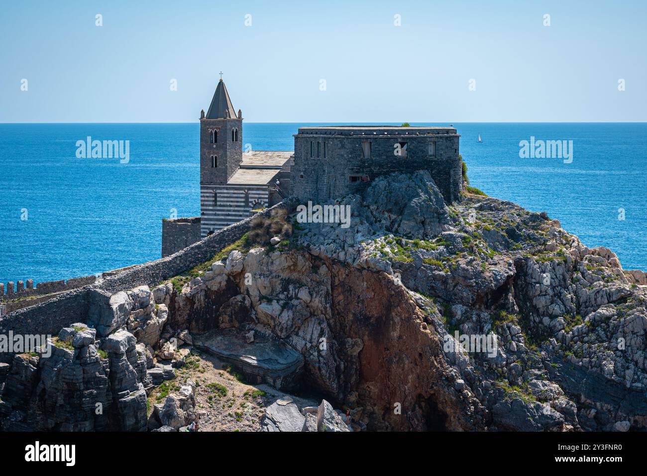 Chiesa di San Pietro fortificata su una piccola penisola rocciosa a Porto Venere, Italia. Mar Ligure color azzurro sullo sfondo. Foto Stock