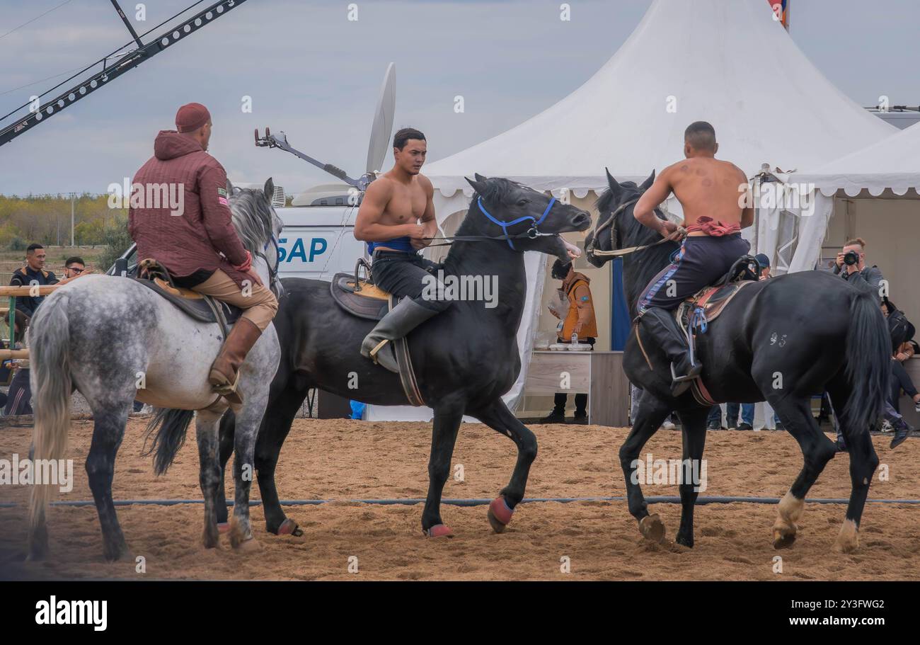 Gli atleti a cavallo lottano nella competizione Audaryspak, una tradizionale lotta per cavalieri, durante i World Nomad Games ad Astana, in Kazakistan. Foto Stock