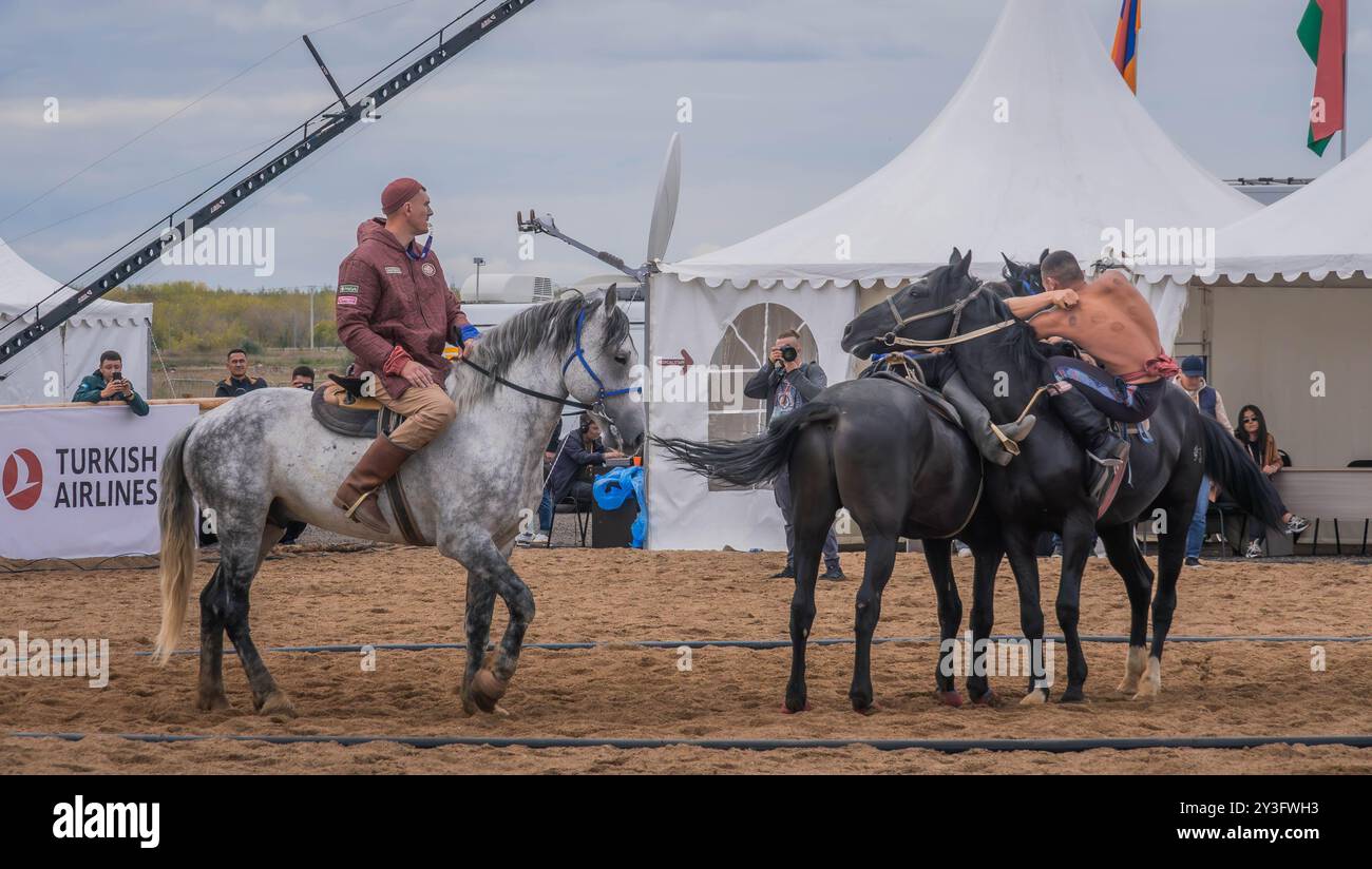 I lottatori partecipano alla competizione Audaryspak, una tradizionale lotta per cavalieri, durante i World Nomad Games ad Astana, in Kazakistan. Foto Stock