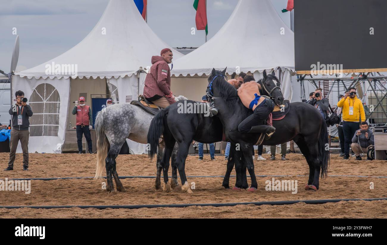 I lottatori partecipano alla competizione Audaryspak, una tradizionale lotta per cavalieri, durante i World Nomad Games ad Astana, in Kazakistan. Foto Stock