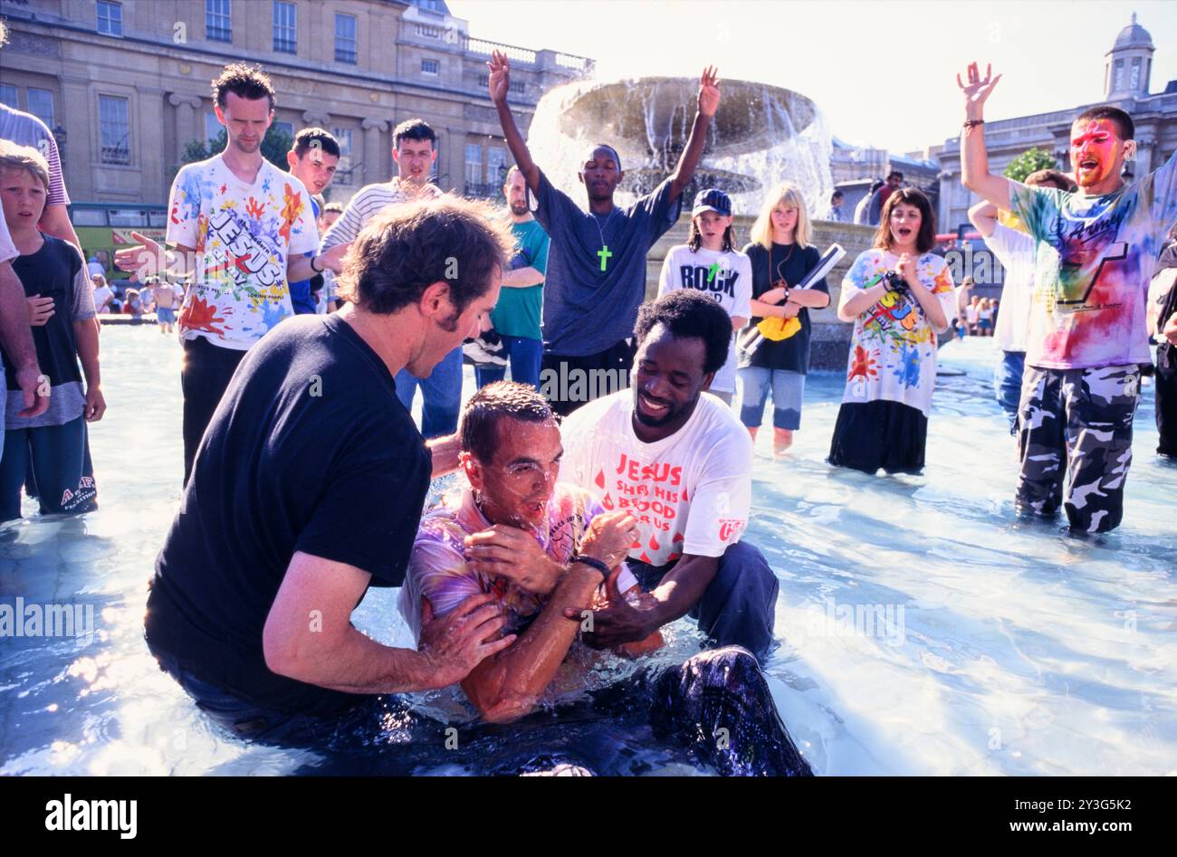 Un uomo battezzato in una fontana di Trafalgar Square durante un Jesus Army Rally. Trafalgar Square, Londra, Regno Unito. Data approssimativa: 1 giugno 1995 Foto Stock