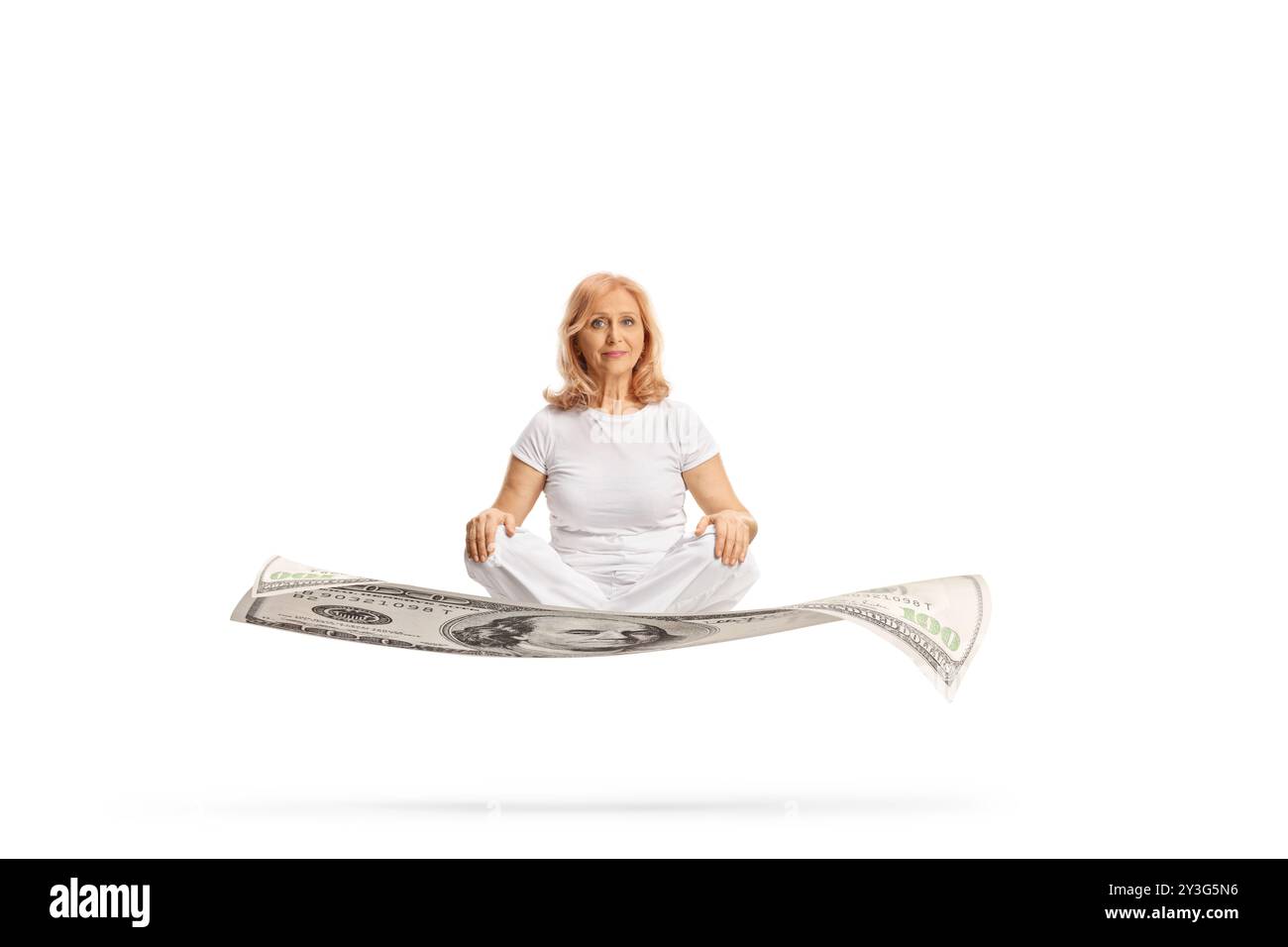 Donna di mezza età in abiti bianchi che galleggia su una banconota da un dollaro isolata su sfondo bianco Foto Stock