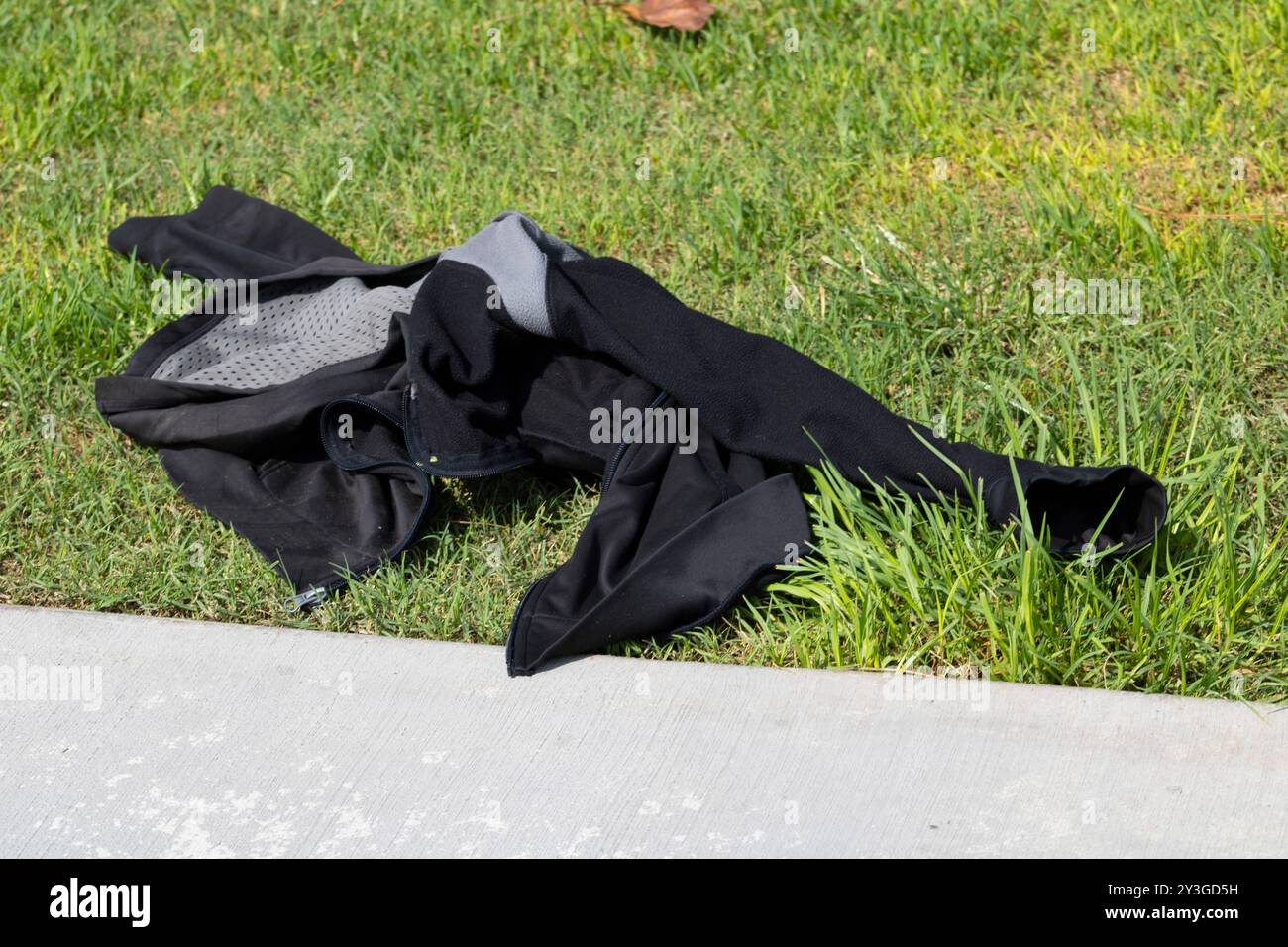 giacca nera e grigia rimasta stesa sull'erba Foto Stock
