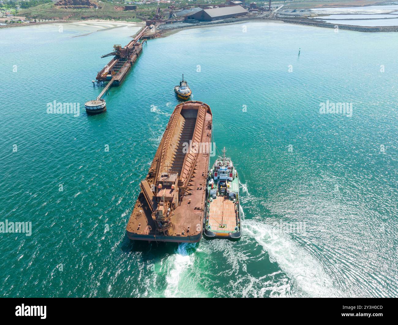 Veduta aerea dei rimorchiatori che dirigono una nave da carico al porto di Whyalla sul golfo di Spencer nell'Australia meridionale. Foto Stock