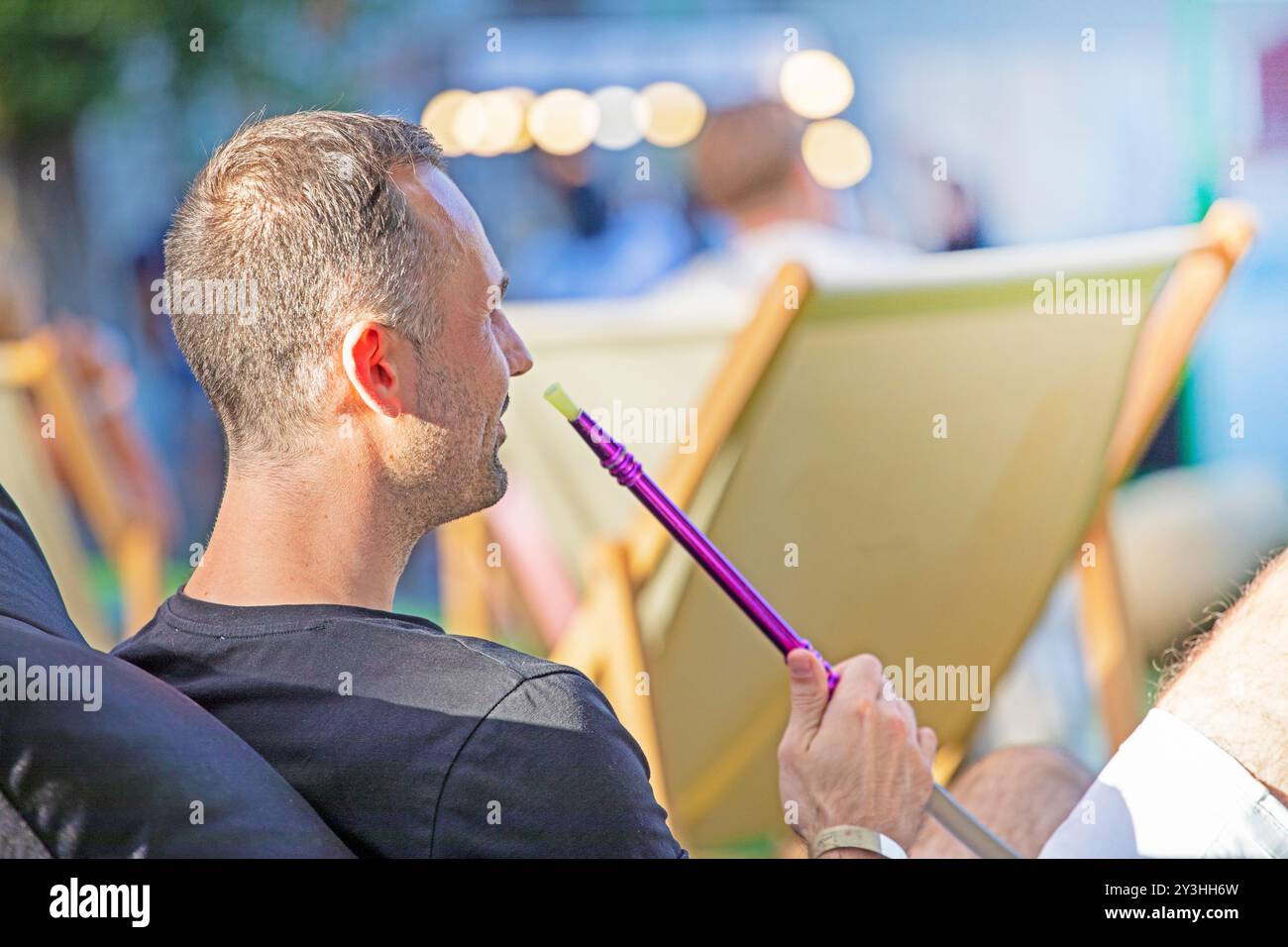cinema estivo all'aperto con spettatori e narghilè in una serata di sole Foto Stock