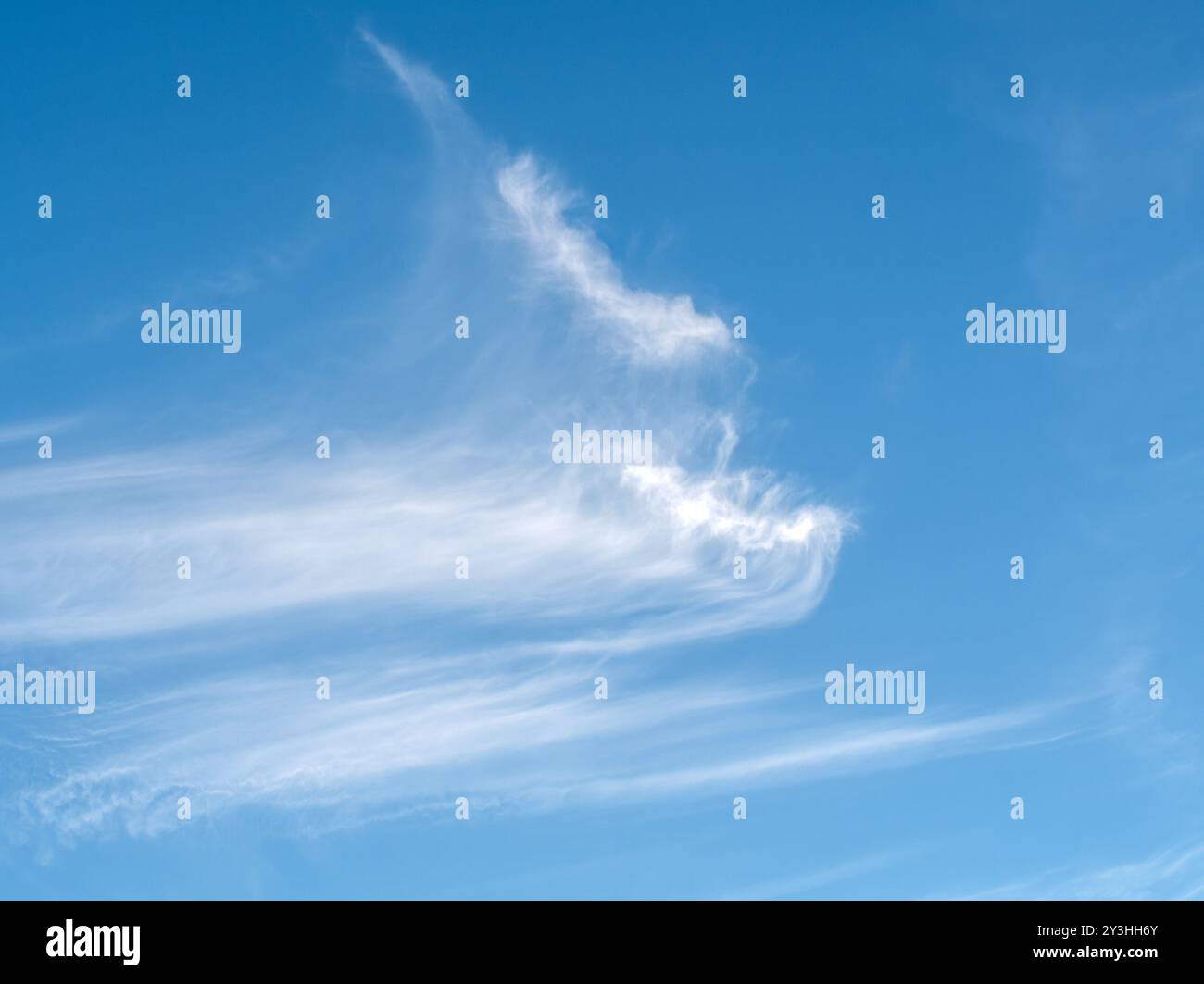 Chiazze di nuvole di Cirrus ad alta quota (code di Mare) contro il cielo azzurro Foto Stock