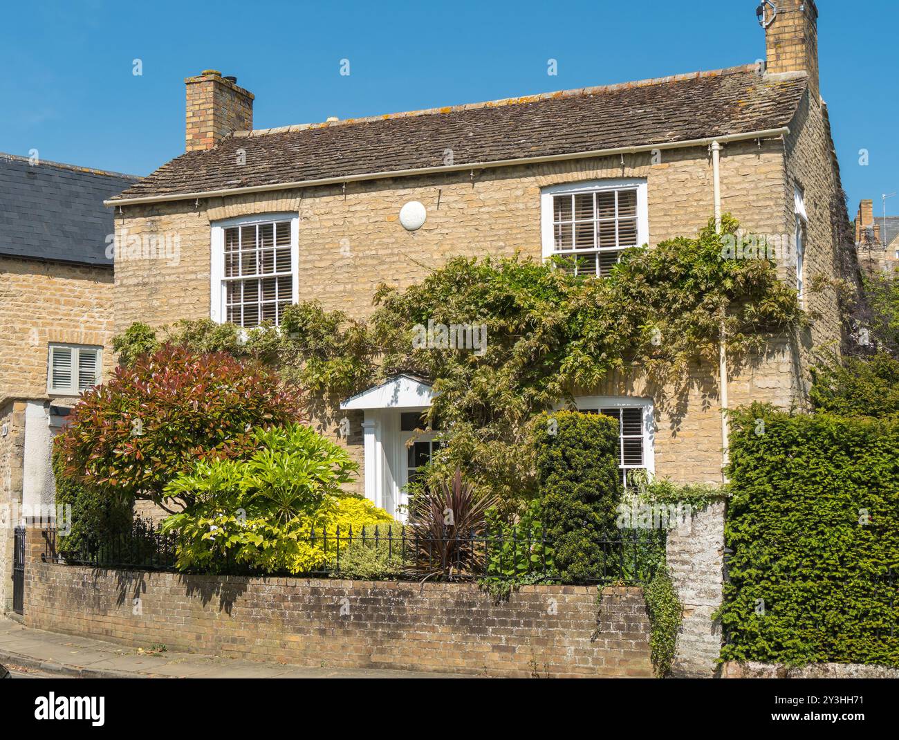 Attraente, vecchia casa in pietra (1826 circa) con glicine arrampicate, finestre a battente georgiane e ringhiere in metallo, Bath Row, Stamford, Inghilterra, Regno Unito Foto Stock