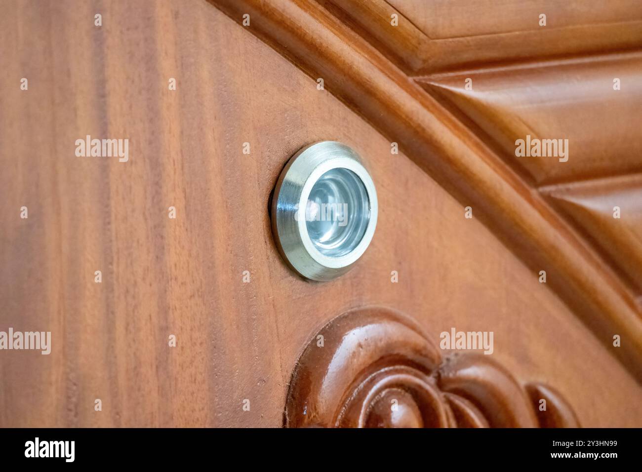 Vista ravvicinata dello spioncino nella porta di legno. È anche chiamato spioncino, spioncino, porta, occhio magico, specchio magico, spioncino. Foto Stock