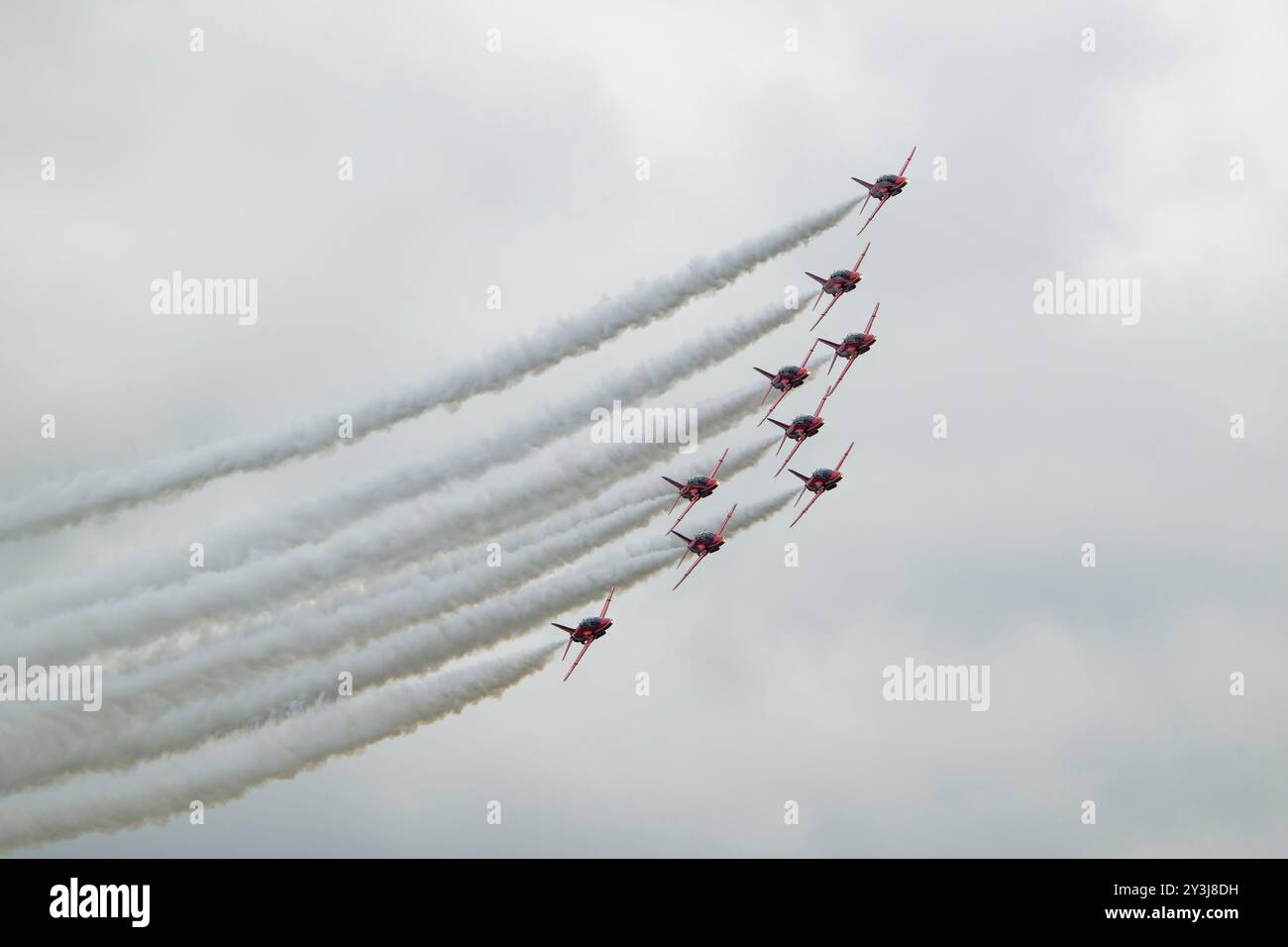 Nove Hawker Siddeley Hawk Jets della British Royal Air Force Red Arrows squadra di esibizione acrobatica in formazione delta e con fumo al RIAT Foto Stock