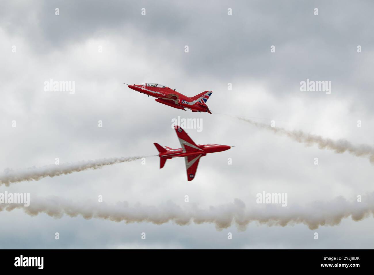 Nel loro 60° anno di attività, due Hawker Siddeley Hawk Jet Trainers della RAF britannica Red Arrows eseguirono un cross over Foto Stock
