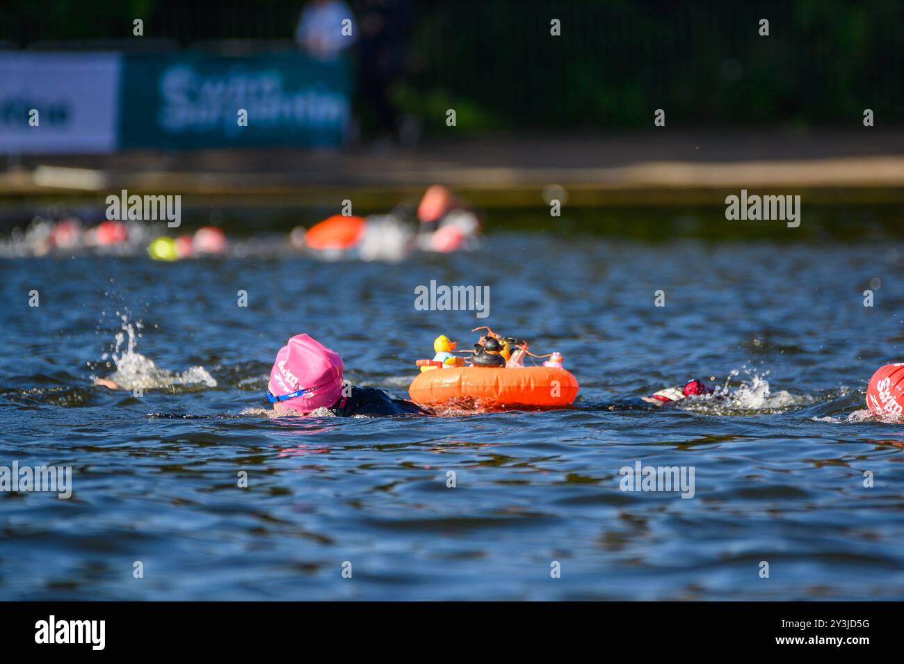 Swim Serpentine nell'Hyde Park di Londra è un evento annuale in cui circa 6.000 nuotatori, di età compresa tra i 10 e i 86 anni, si recano nelle acque fredde per nuotare in una varietà di distanze, tra 800 e 10 km circa. Nessuno è un vincitore, cercano di nuotare al meglio. L'acqua è di 17,5 gradi oggi, ma il sole splende ed è di 19 gradi quando escono dall'acqua. Foto Stock