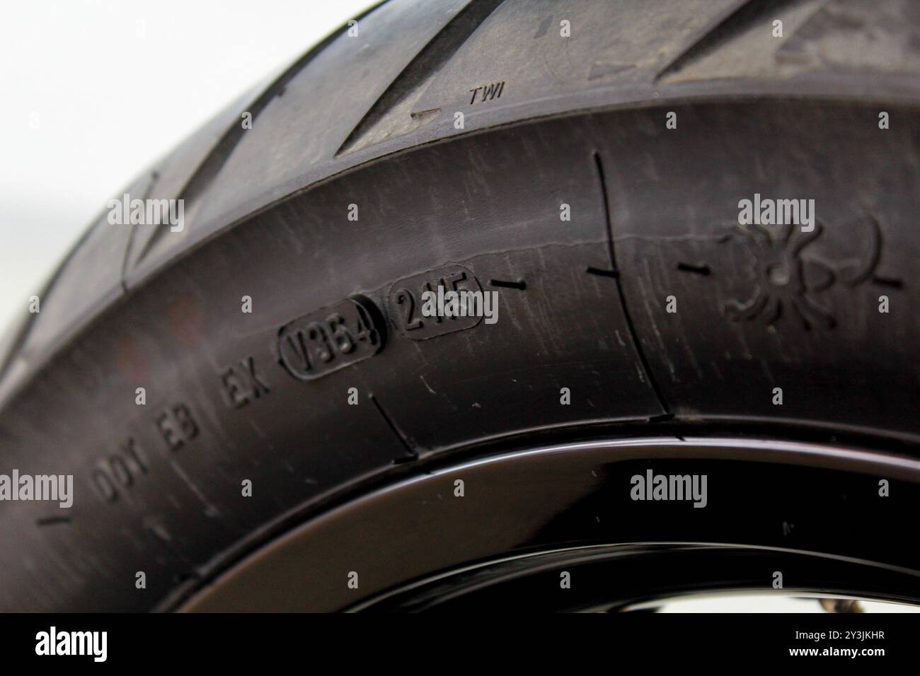 Immagine ravvicinata di uno pneumatico che mostra lo schema del battistrada e i dettagli di fabbricazione, evidenziando la durata e il design per uso automobilistico e industriale Foto Stock