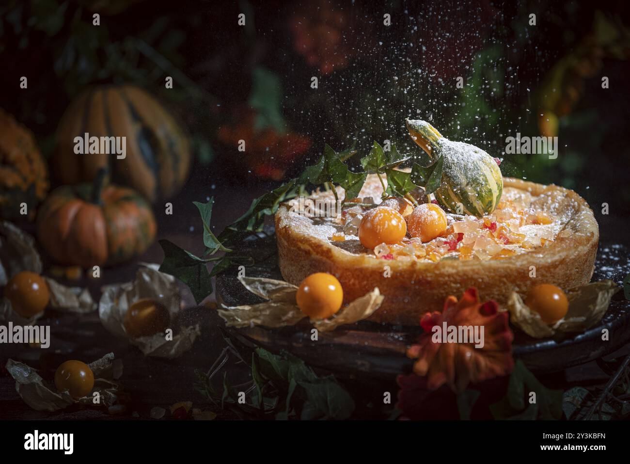 Lo zucchero a velo cade sulla torta autunnale con filis gialli e zucca, atmosfera romantica Foto Stock