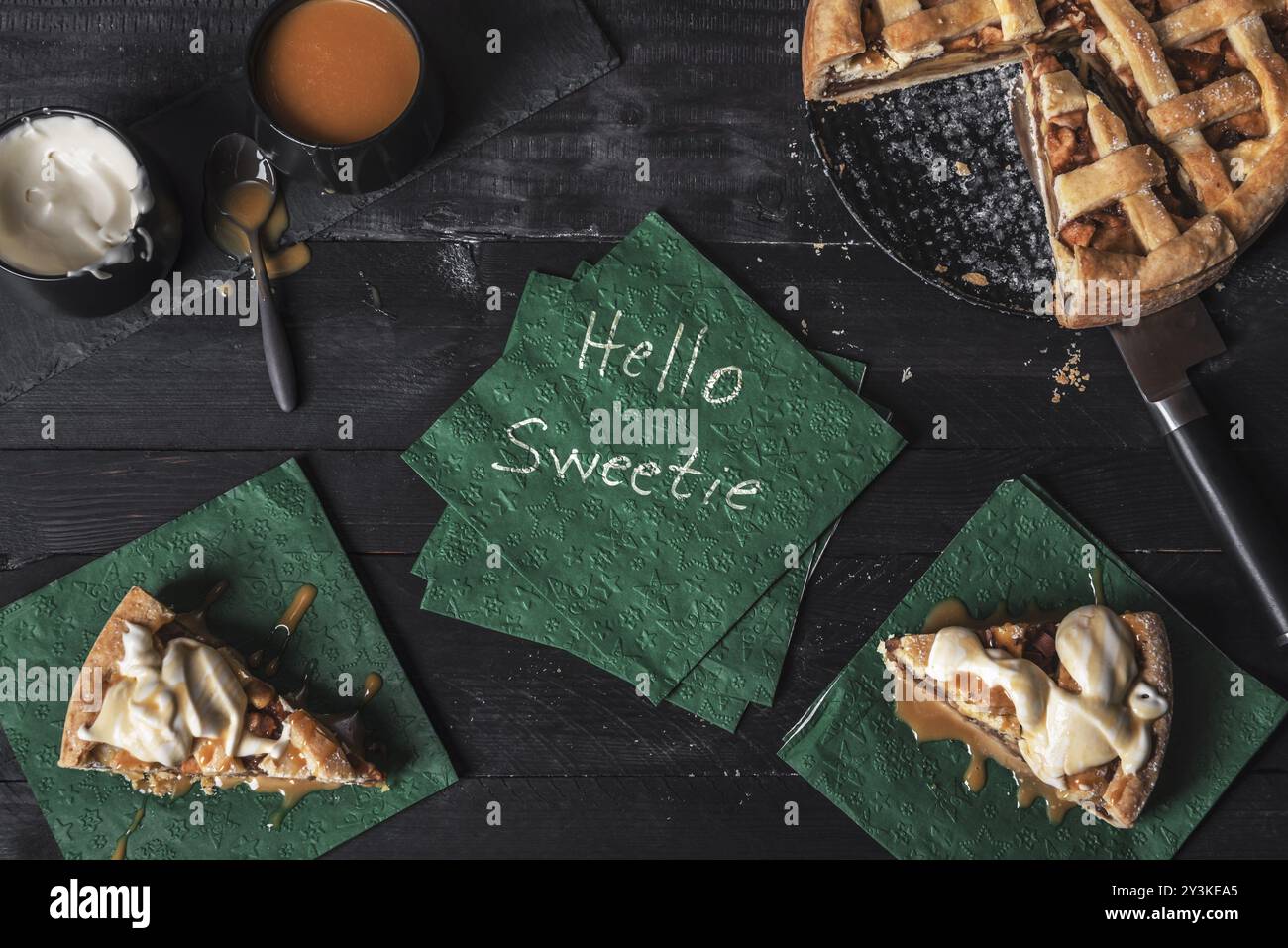 Torta di mele e fette con crema e caramello, e un tovagliolo con le parole ciao dolcezza, su un tavolo. Dolcezza contesto. Dessert tradizionale Foto Stock