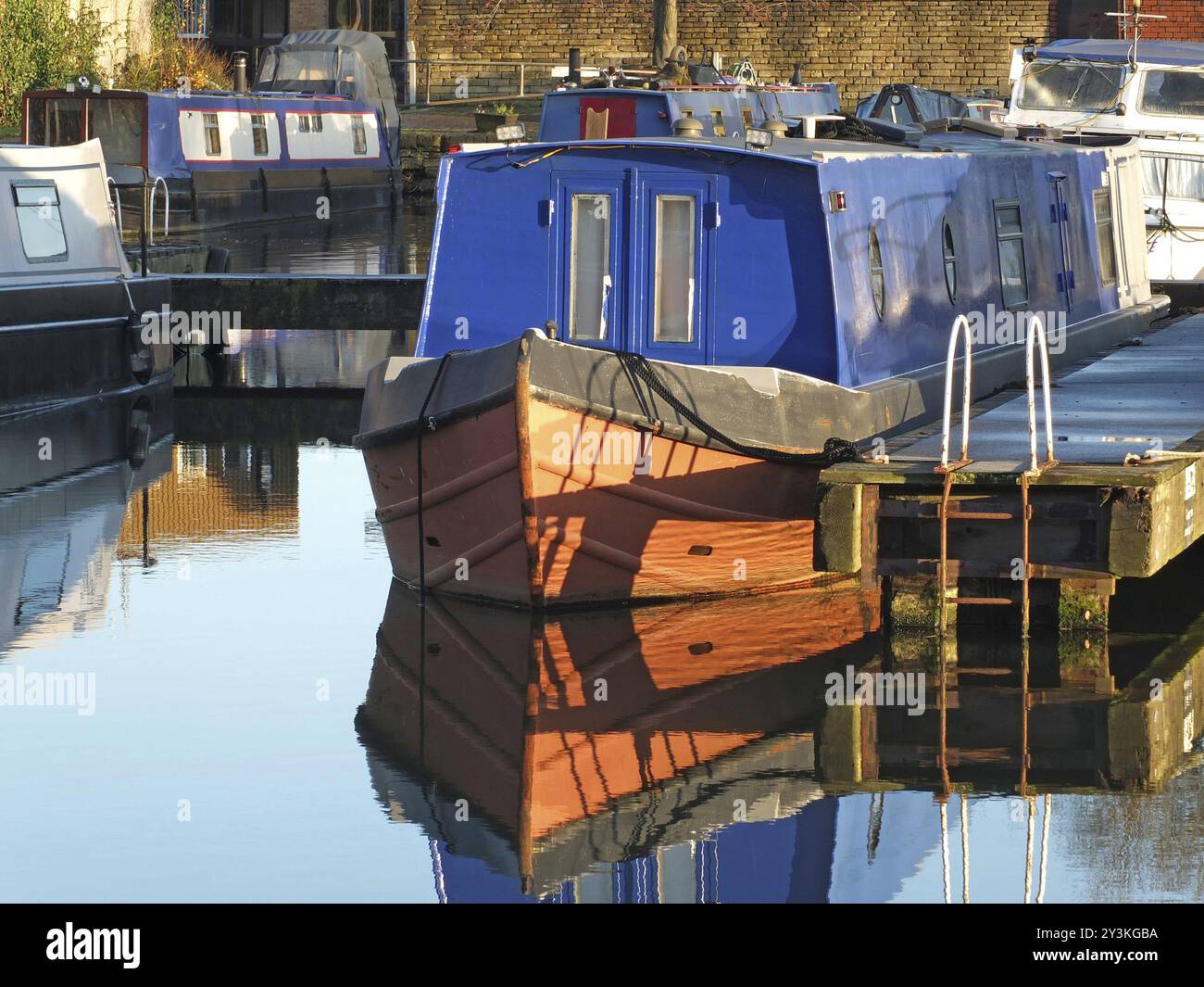 Vecchie e strette barche convertite in case galleggianti ormeggiate nel porto turistico di brighouse Basin nell'ovest dello yorkshire Foto Stock