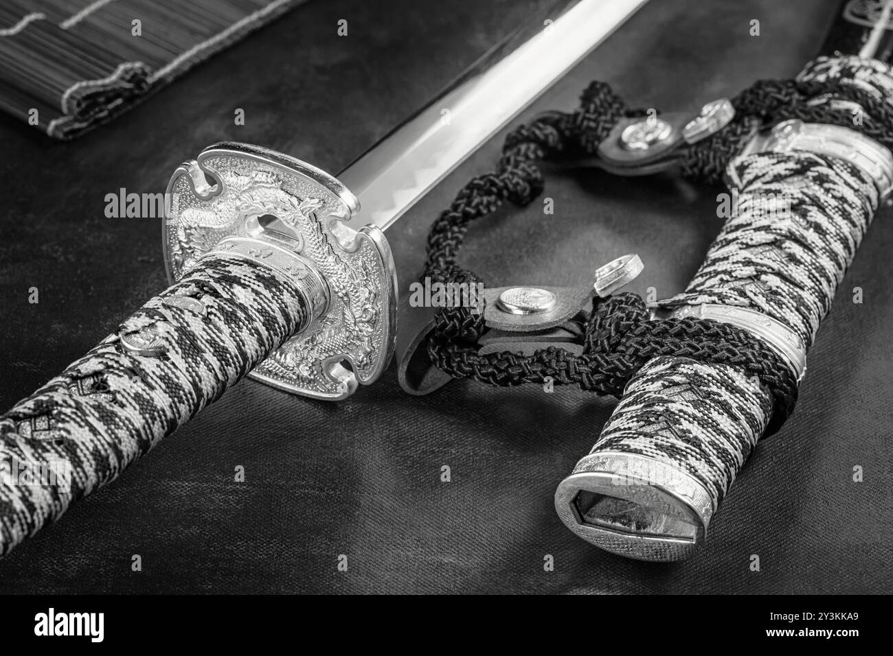La spada giapponese samurai katana e lo scabbard da vicino. Foto di un'arma in basso con messa a fuoco selettiva, in bianco e nero Foto Stock