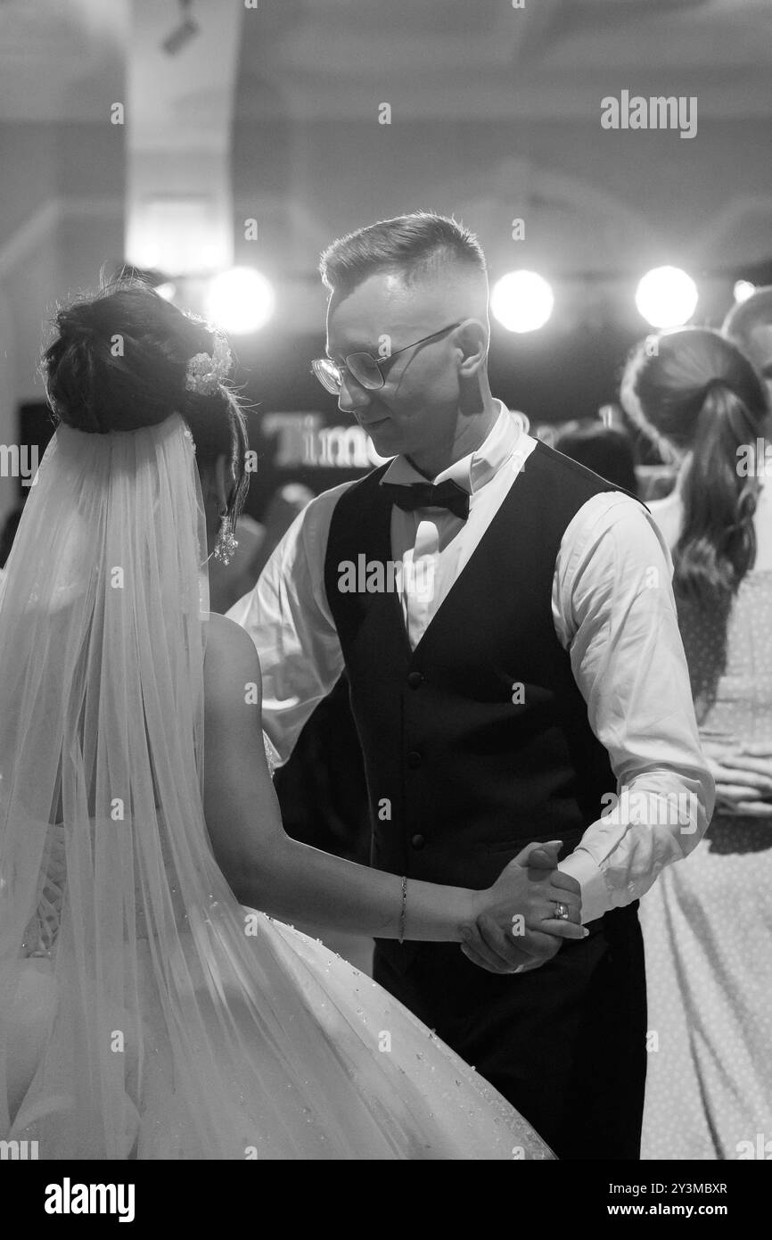 Elegante ballo nuziale bianco e nero che cattura momenti romantici sulla pista da ballo. Foto Stock