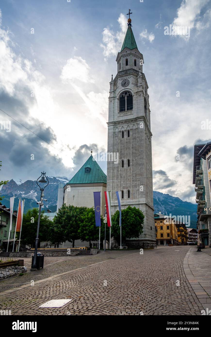 Una vista dell'iconica torre della chiesa nel cuore di Cortina d'Ampezzo. La bellezza architettonica della torre si erge alto sullo sfondo del sur Foto Stock
