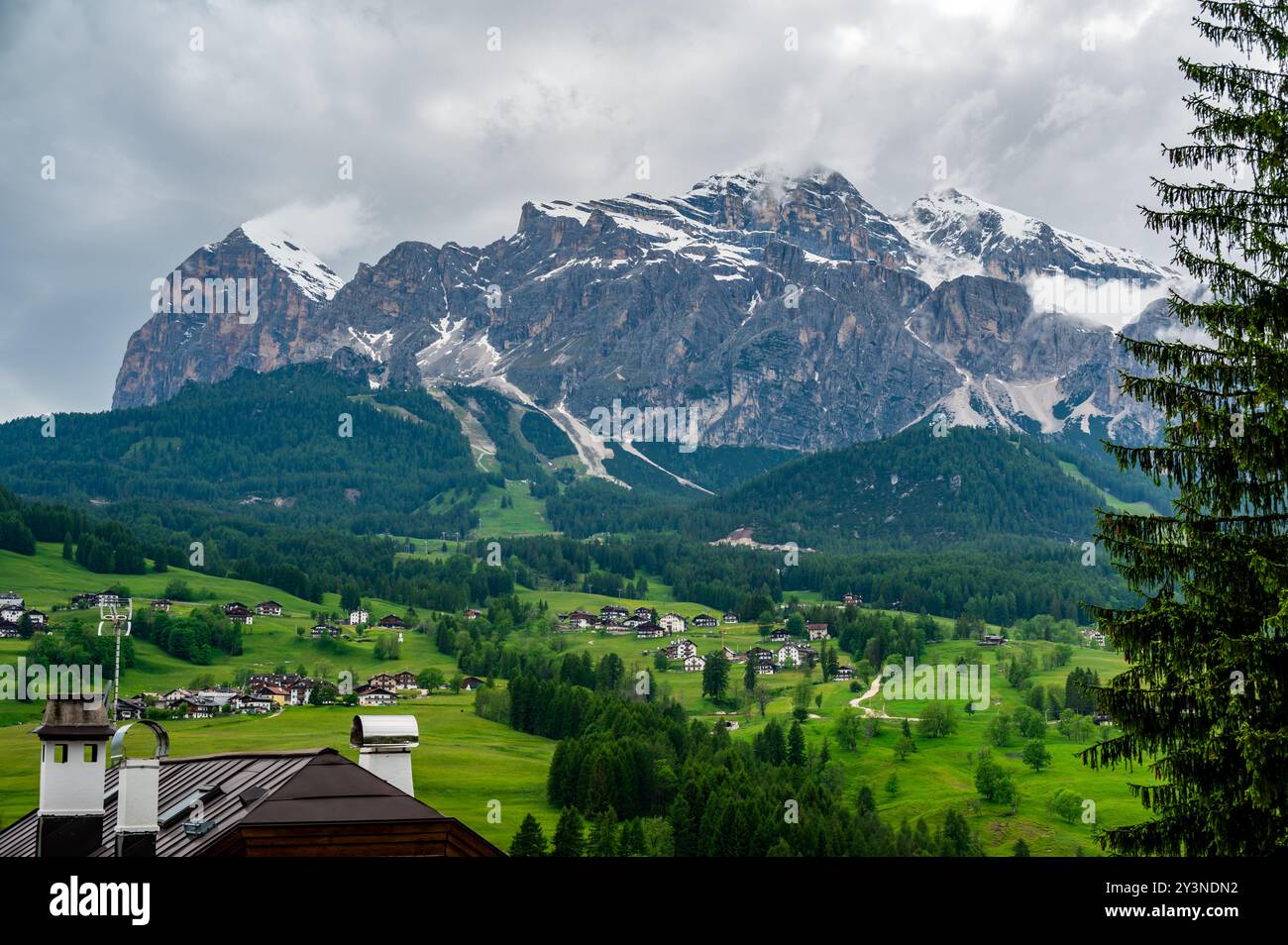 Una vista panoramica sulla pittoresca cittadina di Cortina d'Ampezzo, incastonata nel cuore delle Dolomiti. Montagne maestose si innalzano sullo sfondo, offrono Foto Stock