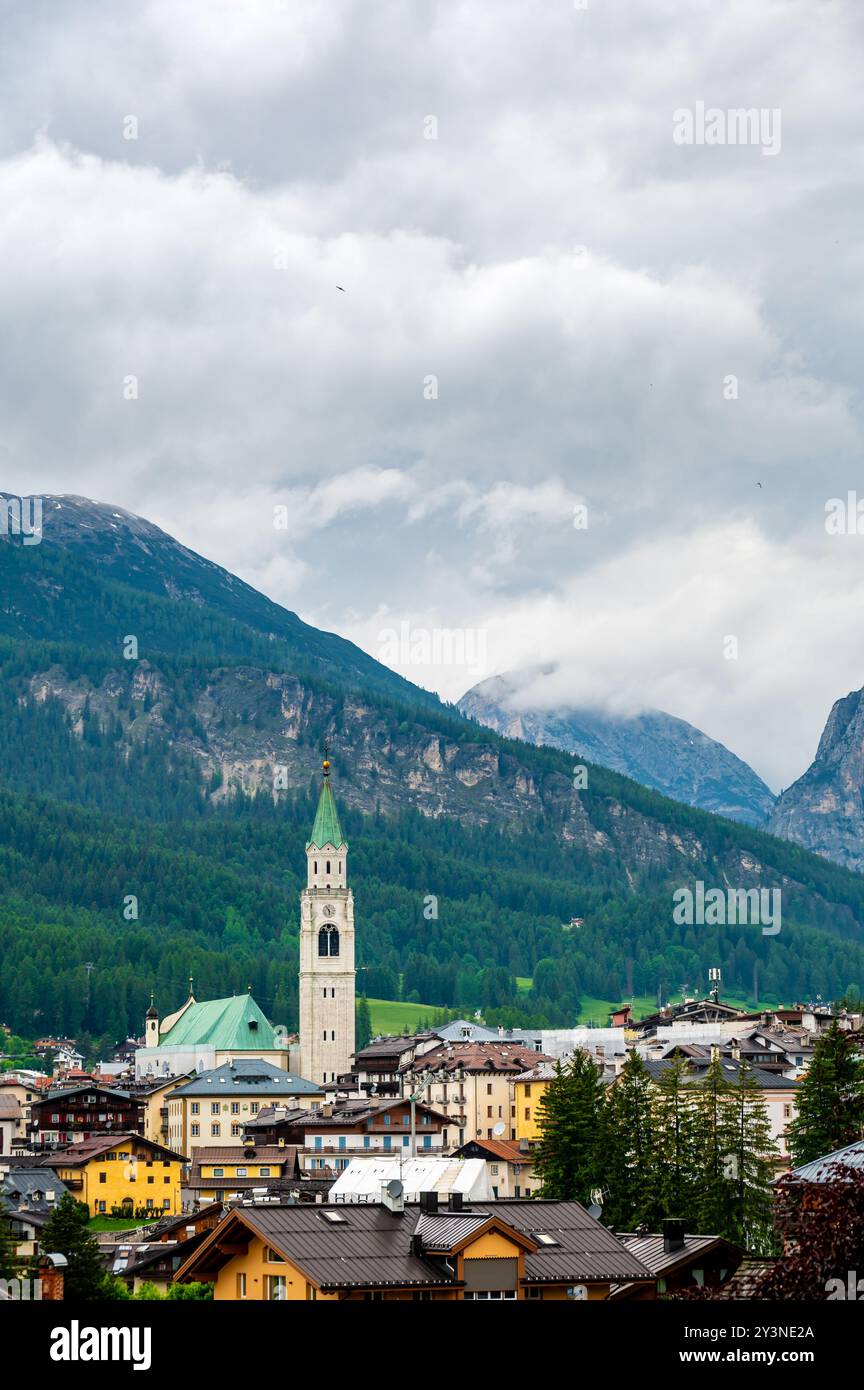Una vista panoramica sulla pittoresca cittadina di Cortina d'Ampezzo, incastonata nel cuore delle Dolomiti. Montagne maestose si innalzano sullo sfondo, offrono Foto Stock