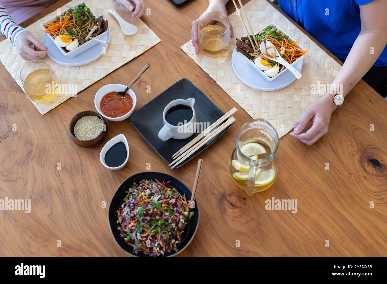 Mangiando cucina asiatica, madre e figlia usano le bacchette e gustando il pasto Foto Stock