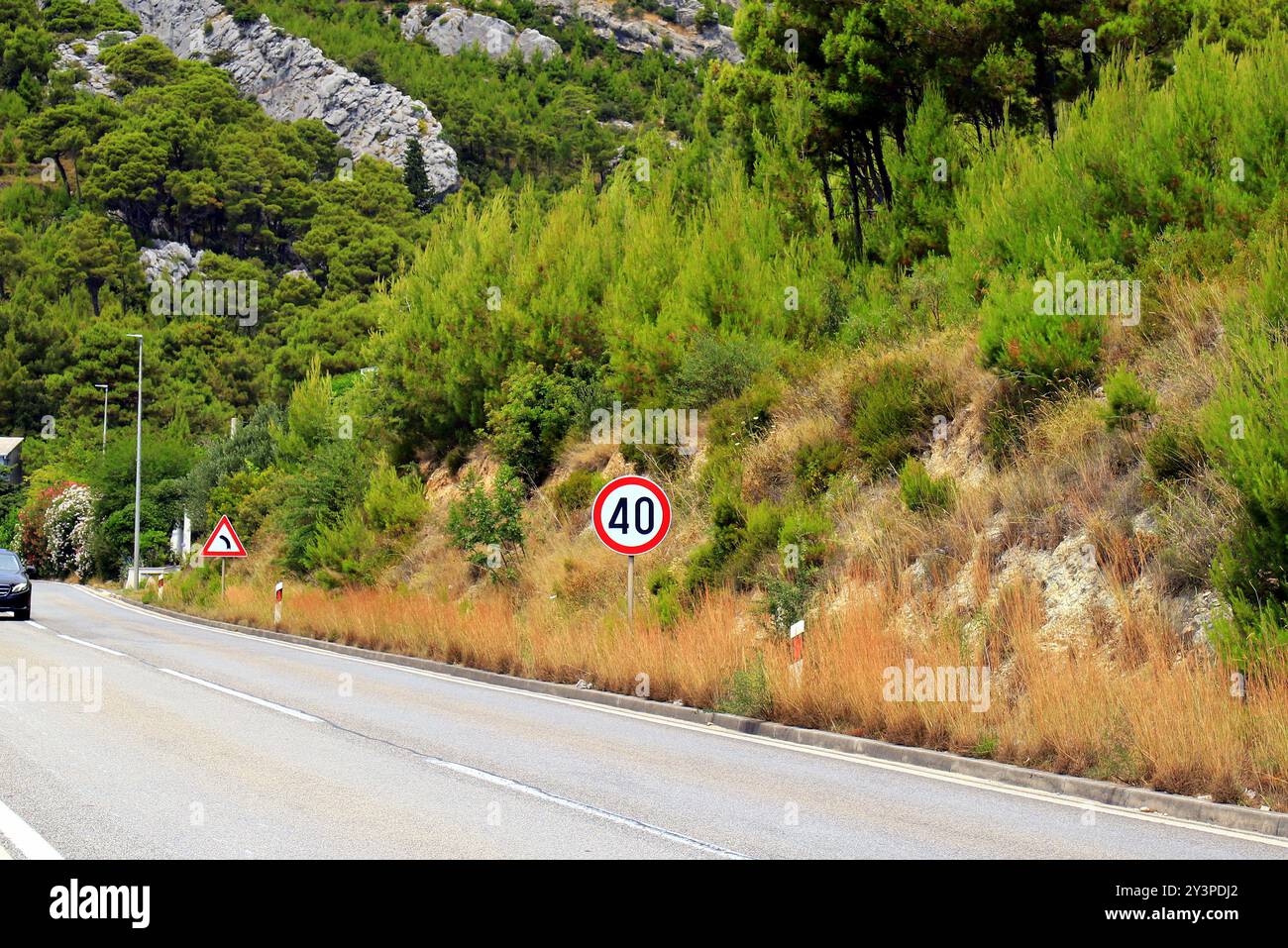 Cartello stradale 80, limite di velocità 80, sulla strada di montagna in Croazia, attenzione selettiva. Segnale del limite di velocità con traffico in background Foto Stock