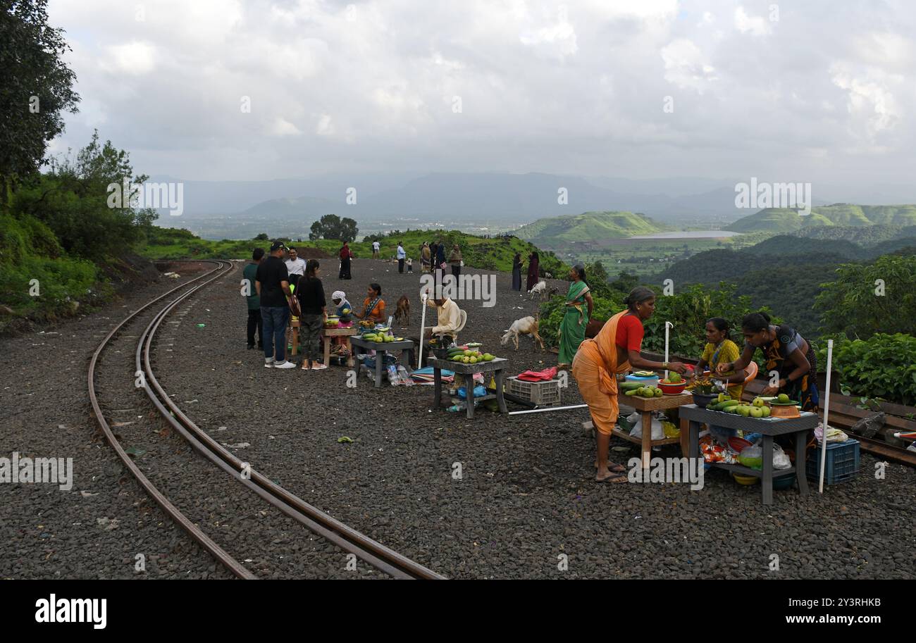 Mumbai, Maharashtra, India. 14 settembre 2024. La gente del posto vende frutta locale e prodotti commestibili ai turisti sulla strada verso la stazione della collina di Matheran nel distretto di Raigad, alla periferia di Mumbai. Matheran è una splendida stazione collinare situata alla periferia della città nel quartiere Raigad di Maharashtra. i veicoli a motore sono vietati nella stazione della collina e i turisti possono prendere un treno giocattolo che va proprio all'interno della stazione della collina da dove i turisti possono camminare o noleggiare un risciò trainato a mano o andare a cavallo per visite turistiche all'interno e intorno alla stazione della collina. mese monsone Foto Stock