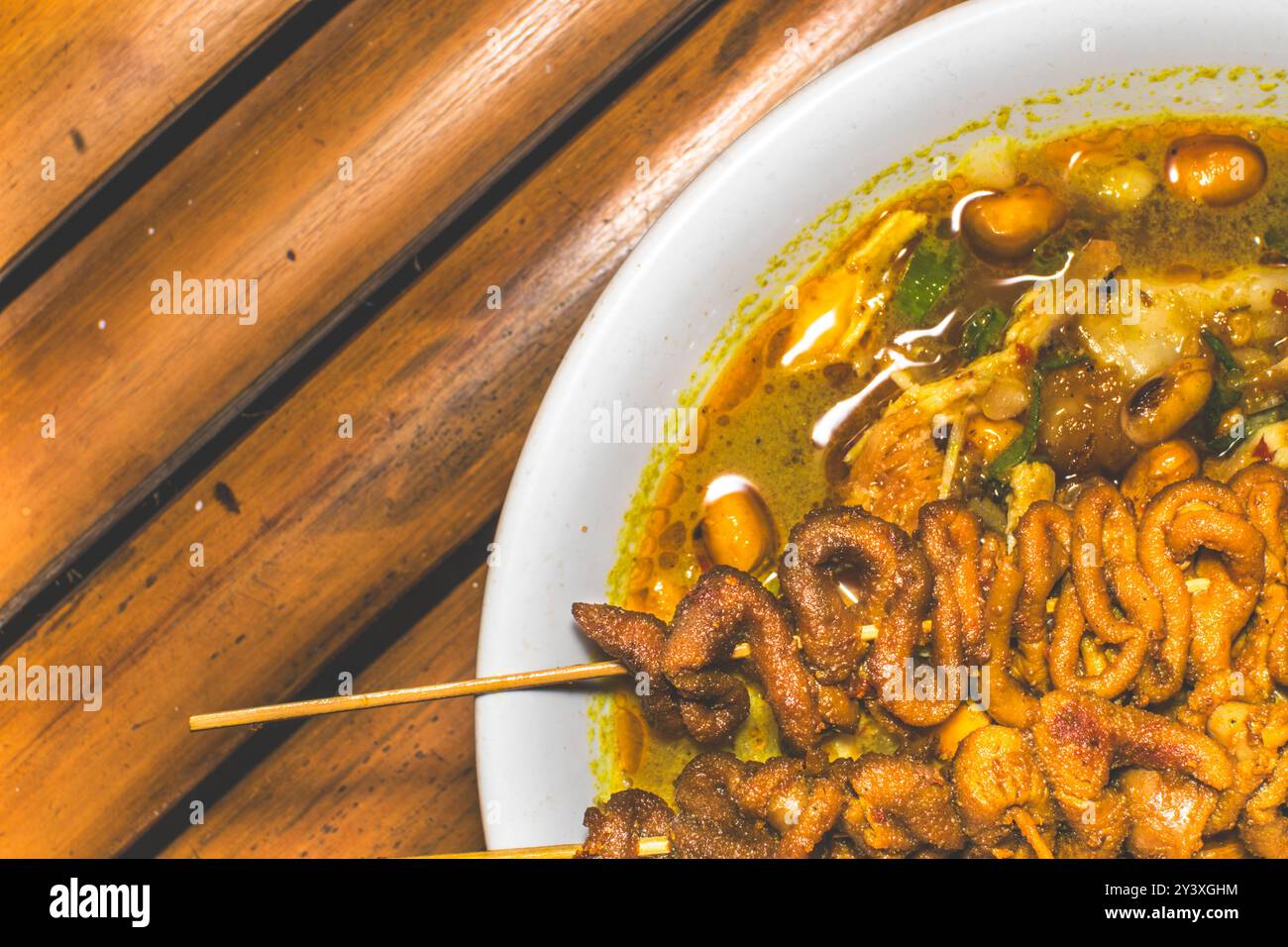 Ciotola di porridge di pollo servita con piatti unici. Tradizionale porridge di pollo con piatti satay all'intestino di pollo, autentica tradizione indonesiana Foto Stock