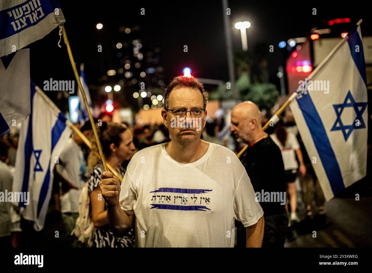 Tel Aviv, Israele. 14 settembre 2024. Un uomo israeliano la sua maglietta recita in ebraico: "Non ho nessun altro paese" tiene la sua bandiera nazionale durante una manifestazione a Tel Aviv sabato 14 settembre 2024.decine di migliaia di persone si sono radunate a Tel Aviv e in Israele, chiedendo al primo ministro Benjamin Netanyahu e al suo governo di raggiungere un accordo per garantire il rilascio dei restanti ostaggi presi da Hamas durante gli attacchi del 7 ottobre. Crediti: Eyal Warshavsky/Alamy Live News Foto Stock