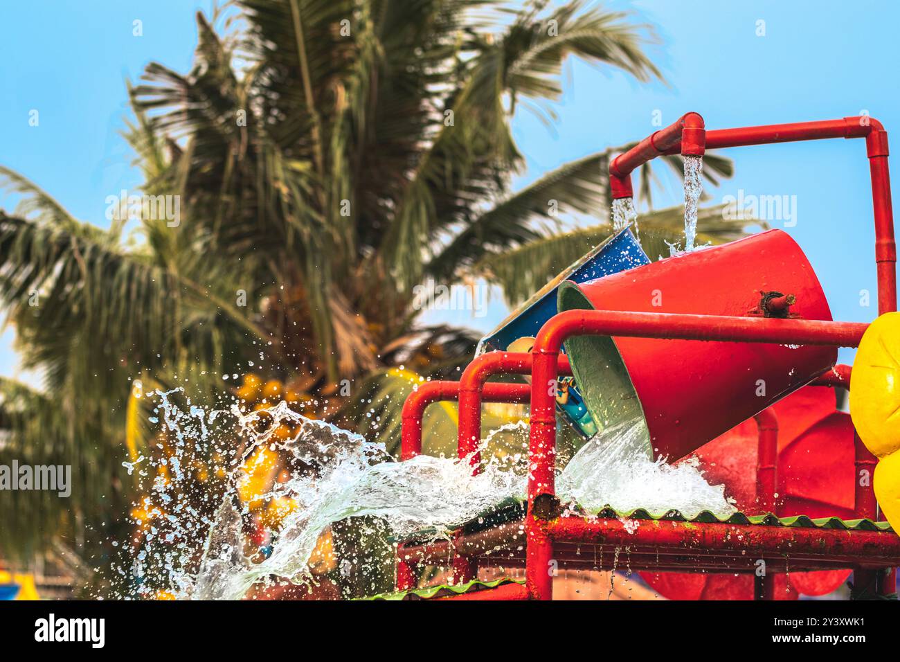 L'acqua fuoriesce dall'attrazione del secchio d'acqua del parco acquatico. Spruzzi d'acqua sul secchio ribaltabile o sul secchio d'acqua in piscina. Parco acquatico e piscina Foto Stock