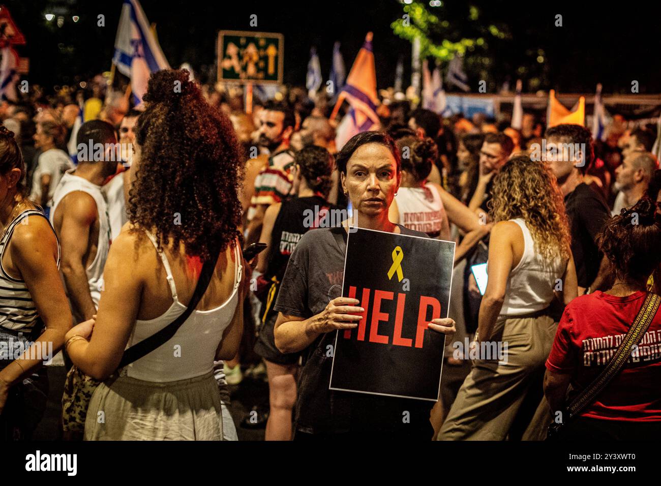 Tel Aviv, Israele. 14 settembre 2024. Una donna israeliana ha un segno che recita: "Aiuto" durante una manifestazione a Tel Aviv sabato 14 settembre 2024.decine di migliaia di persone si sono radunate a Tel Aviv e in Israele, chiedendo al primo ministro Benjamin Netanyahu e al suo governo di raggiungere un accordo per garantire il rilascio dei restanti ostaggi presi da Hamas durante gli attacchi del 7 ottobre. Crediti: Eyal Warshavsky/Alamy Live News Foto Stock