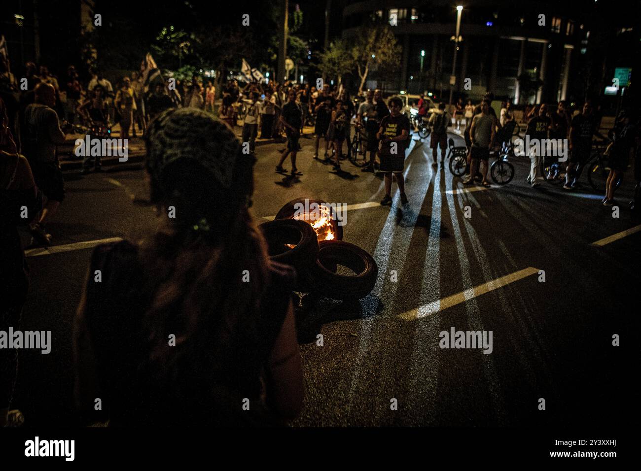 Tel Aviv, Israele. 14 settembre 2024. I manifestanti israeliani si riuniscono intorno alle gomme in fiamme durante una manifestazione a Tel Aviv sabato 14 settembre 2024.decine di migliaia di persone si sono radunate a Tel Aviv e in Israele, chiedendo al primo ministro Benjamin Netanyahu e al suo governo di raggiungere un accordo per garantire il rilascio dei restanti ostaggi presi da Hamas durante gli attacchi del 7 ottobre. Crediti: Eyal Warshavsky/Alamy Live News Foto Stock