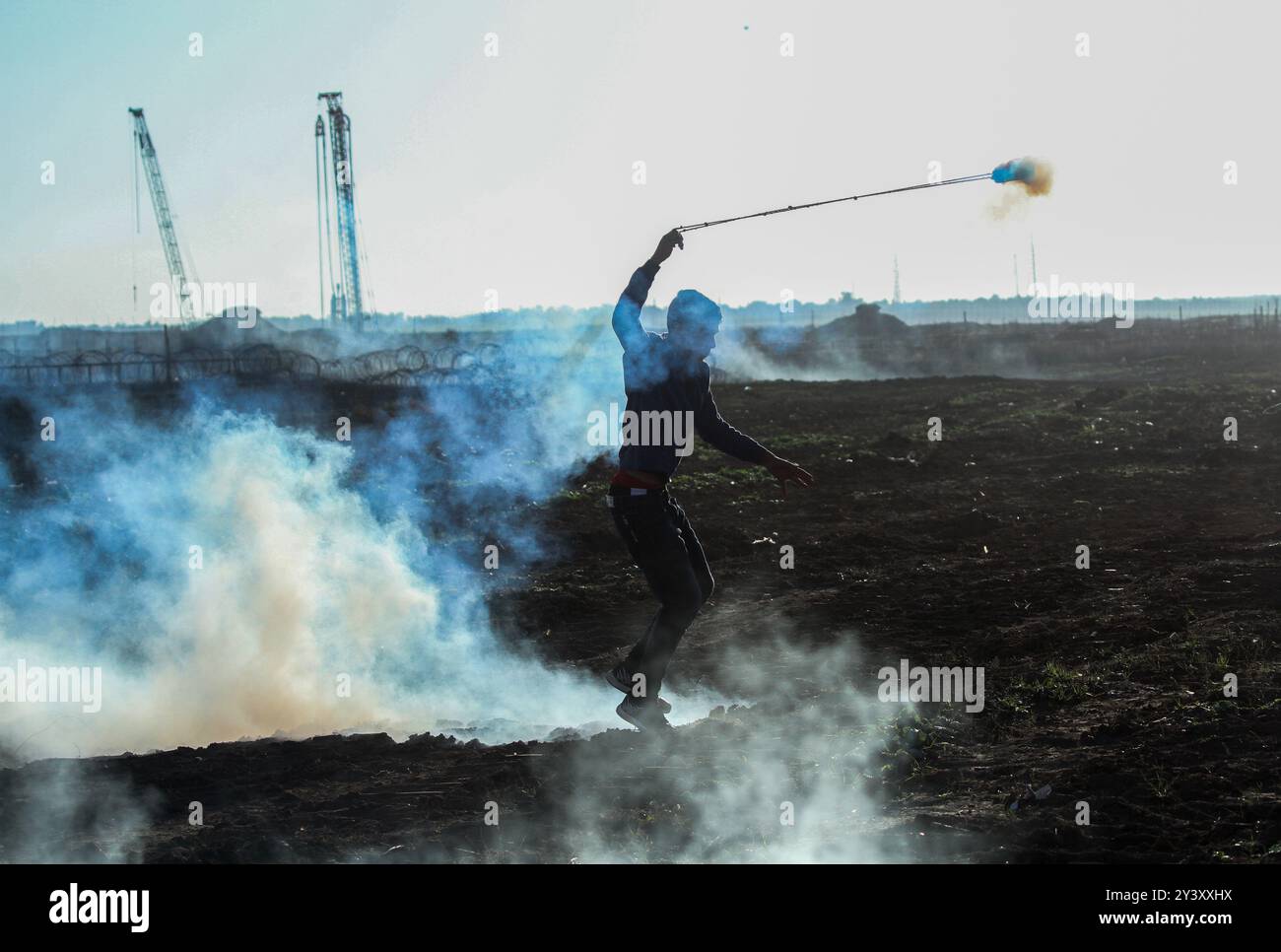 Gaza, Palestina. 20 dicembre 2019. I giovani palestinesi si scontrano con i soldati israeliani ad Abu Safiya, nella parte settentrionale della Striscia di Gaza, durante le proteste di frontiera di questo venerdì. Centinaia di manifestanti si erano riuniti venerdì pomeriggio in diversi siti chiusi al confine tra Gaza e Israele, come parte della grande marcia di rimpatrio. Decine di manifestanti palestinesi sono stati feriti venerdì a causa del gas lacrimogeno e del fuoco dei soldati israeliani. Dal marzo 30 dello scorso anno, i manifestanti a Gaza chiedono la fine del blocco israeliano di 12 anni sulla Striscia di Gaza. Il blocco ha paralizzato l'economia dell'alre Foto Stock