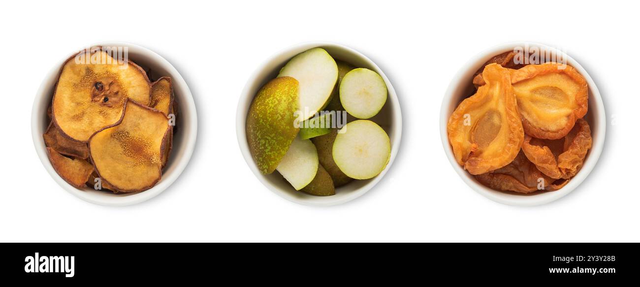 Ciotole piatti con fette di pera verde crude mature e secche isolate su sfondo bianco. Foto Stock