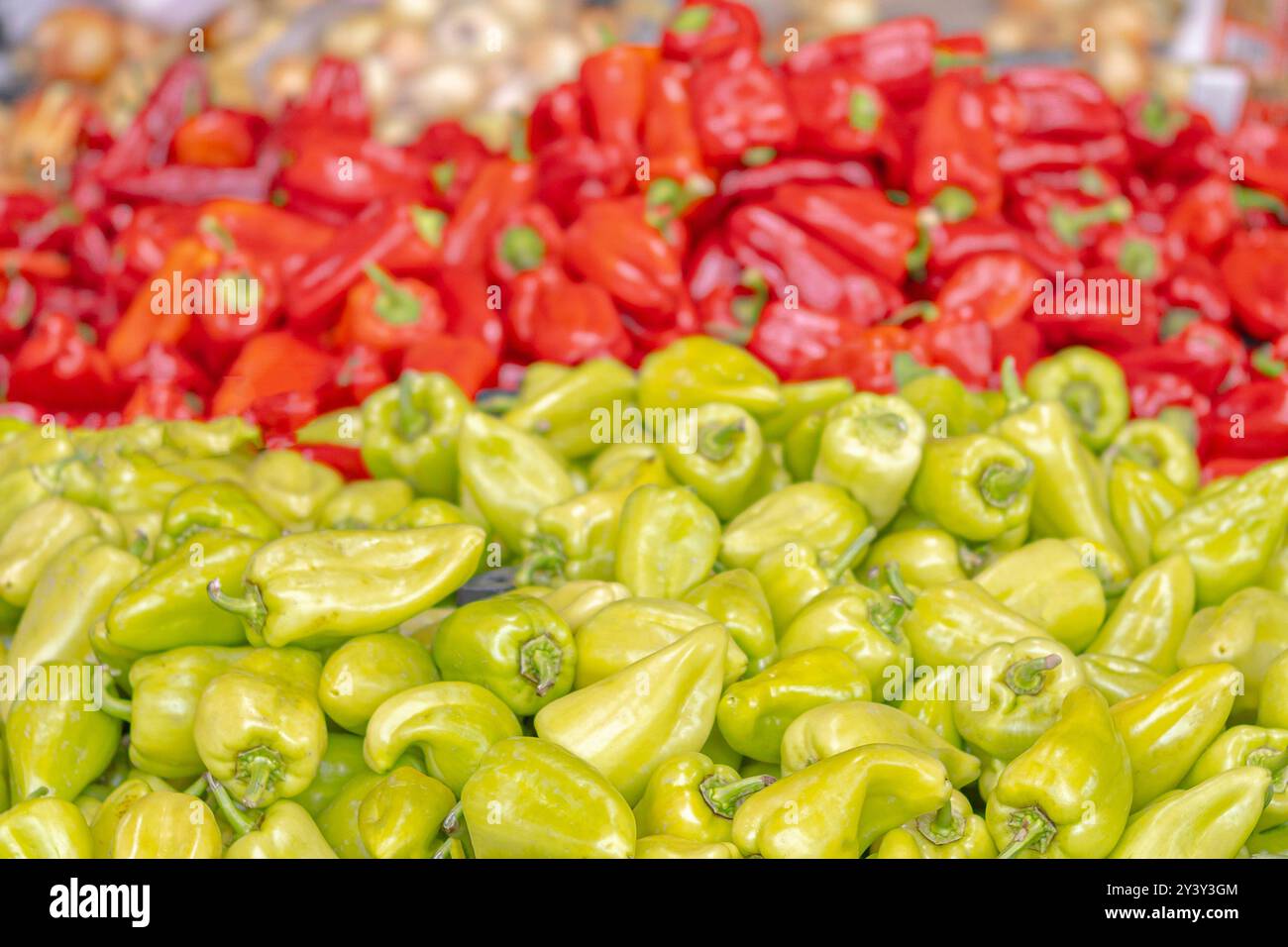 Un gruppo di peperoni verdi e rossi viene esposto in un mercato Foto Stock