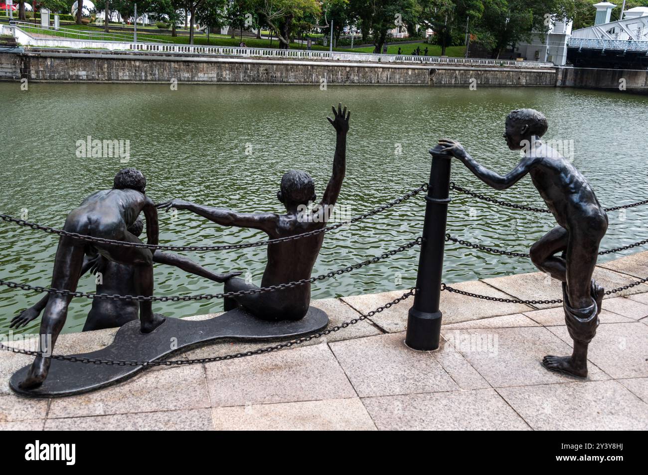 Tre dei cinque giovani scolpiti in bronzo sono saltati nel fiume Singapore vicino al Cavenagh Bridge di Singapore. Questo è un ritorno nostalgico al Foto Stock