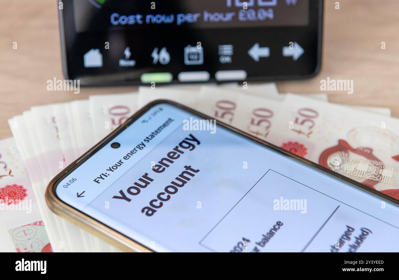 Un concetto di consumo energetico e costi con bolletta digitale su un telefono cellulare, un contatore di energia intelligente e banconote. Foto Stock