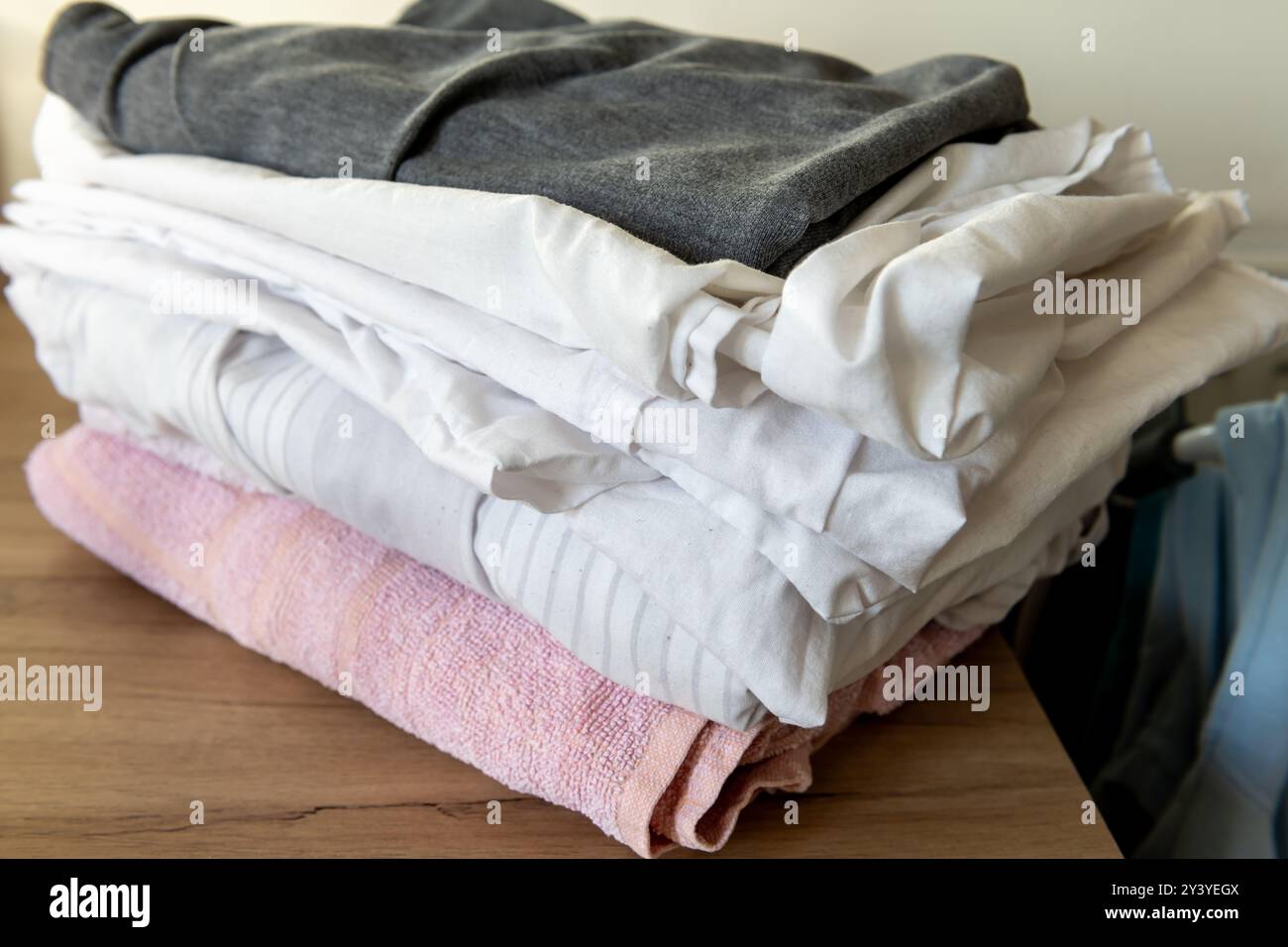 Primo piano di una pila di indumenti piegati asciutti su un piano di lavoro. Lavanderia a domicilio. Foto Stock