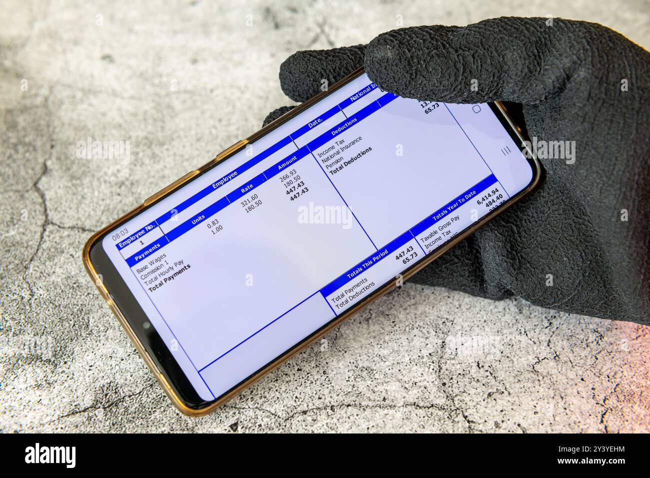 Londra. REGNO UNITO- 09.12.2024. Un lavoratore che indossa guanti da lavoro e tiene in mano un cellulare con uno stipendio digitale. Foto Stock