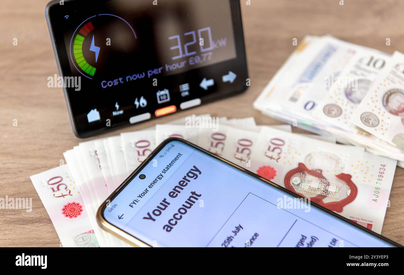 Un concetto di consumo energetico e costi con bolletta digitale su un telefono cellulare, un contatore di energia intelligente e banconote. Foto Stock