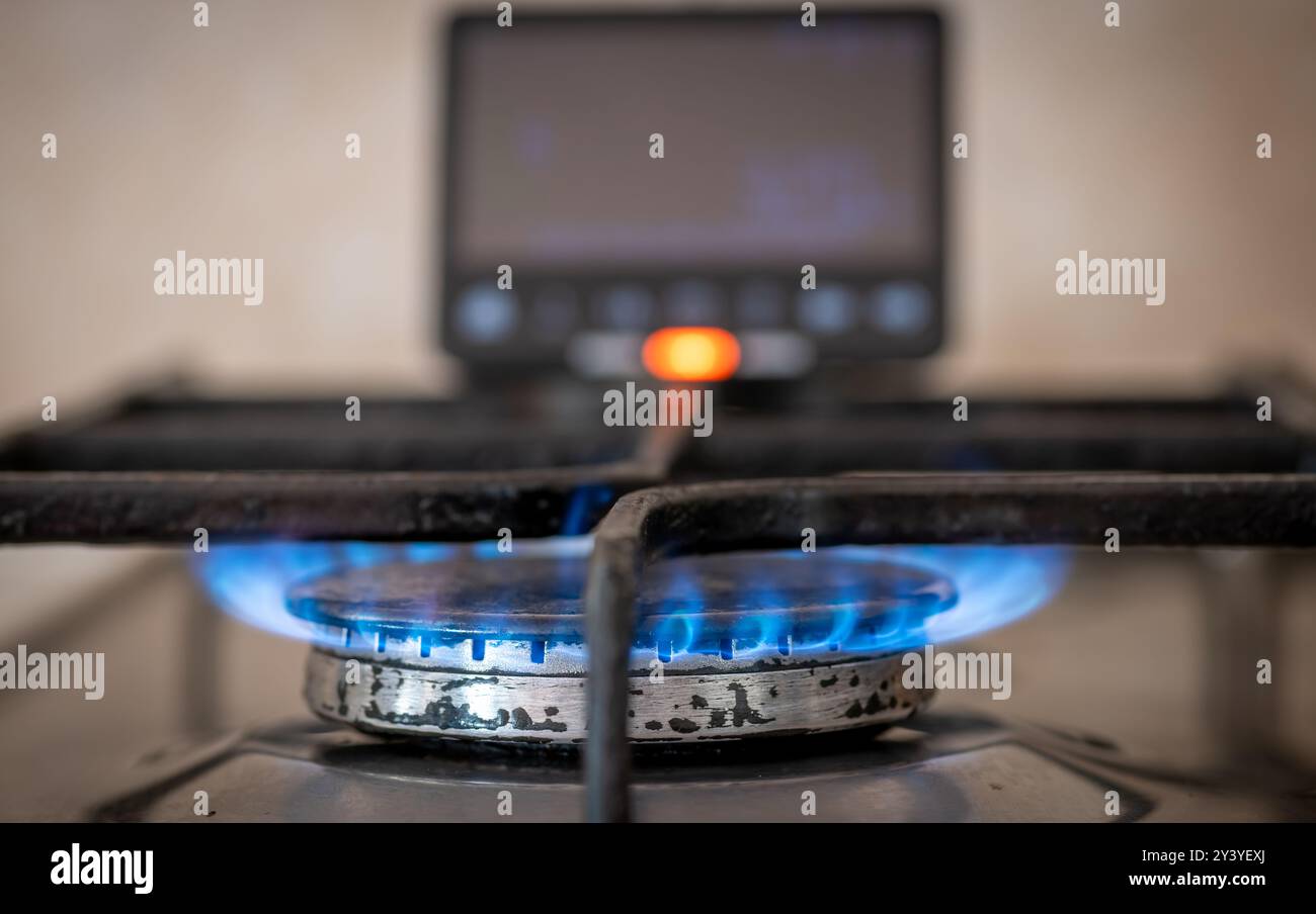 Un concetto di consumo energetico e di costo con un contatore energetico intelligente vicino a un fornello a gas. Foto Stock