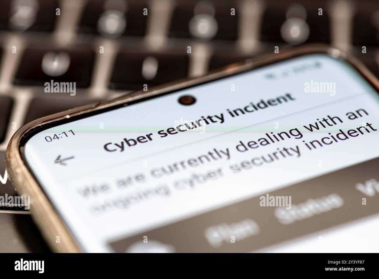 Primo piano di un messaggio su un telefono cellulare di un'azienda che informa i propri clienti di un incidente di sicurezza informatica in corso. Foto Stock