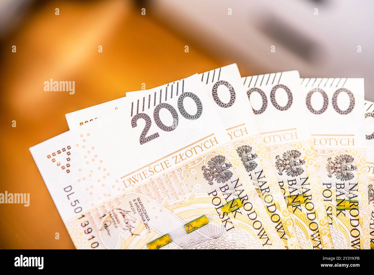 Vista ravvicinata di diverse banconote zloty polacche mostrò in modo prominente, evidenziando il taglio da 200 zloty utilizzato negli acquisti quotidiani ed economici Foto Stock