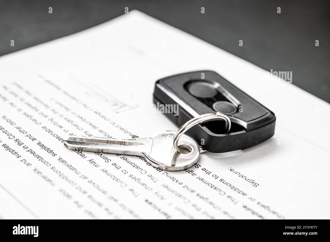Chiave e telecomando appoggiati su contratto di ristrutturazione, che indica il controllo dell'accesso per cancelli residenziali. Essenziale per proprietari di abitazioni e appaltatori che gestiscono correttamente Foto Stock