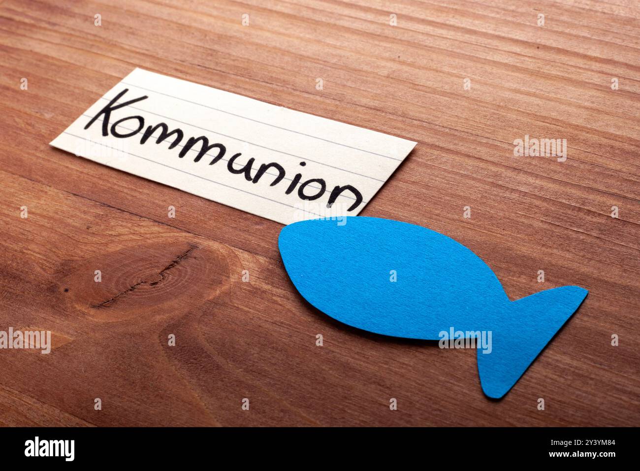 Comunione. Parola tedesca. Pesce blu nell'angolo. Stendendo su legno. Spazio libero per il testo. Spazio libero per il testo. Foto Stock