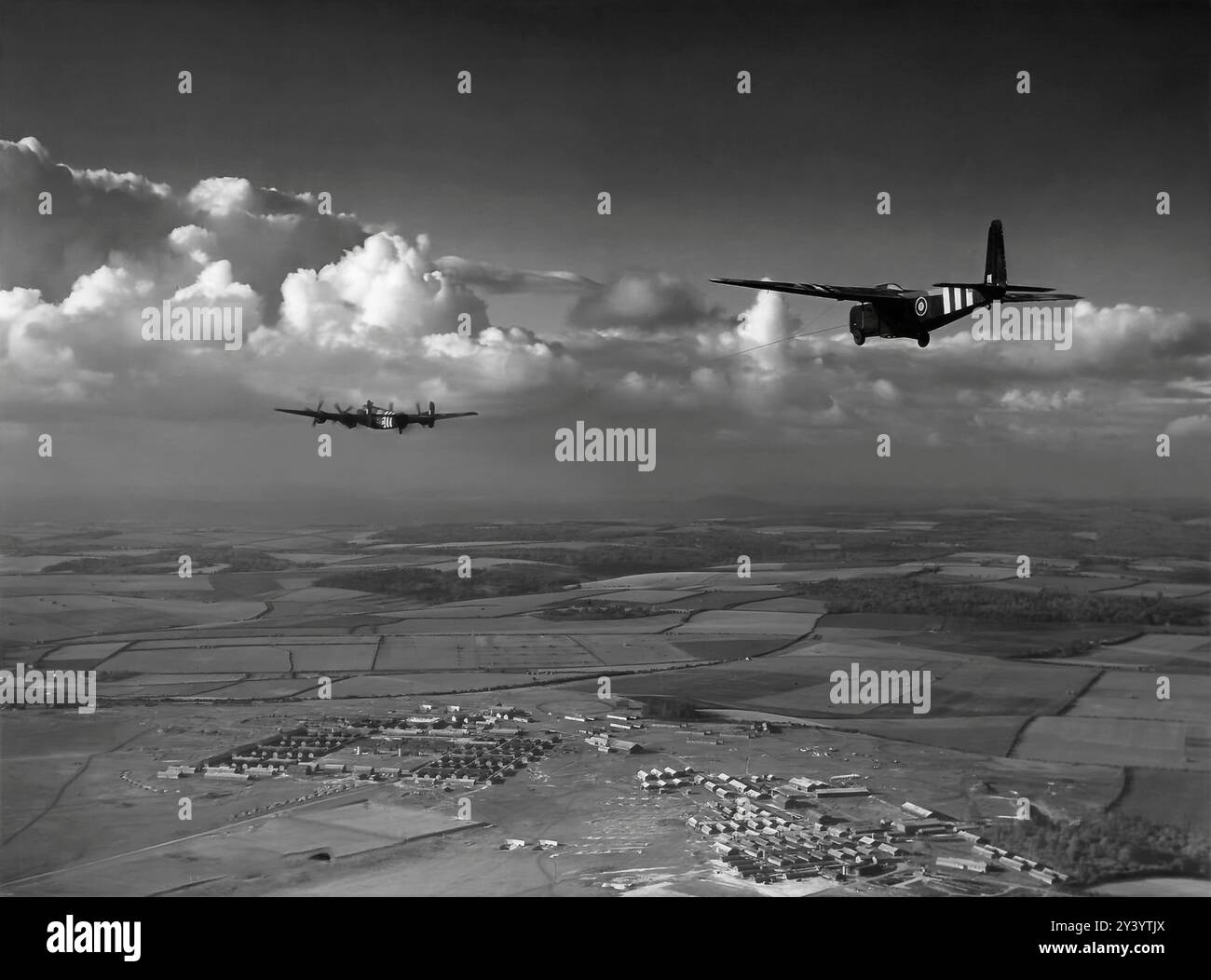 Un Handley Page Halifax, bombardiere pesante a quattro motori della Royal Air Force durante la seconda guerra mondiale che traina un aliante Hamilcar. I più grandi aerei in legno costruiti durante la seconda guerra mondiale potevano trasportare carichi diversi, come un carro armato Tetrarch Mark IV o un carro armato Locust, due portaerei universali Bren-gun o due vagoni da ricognizione corazzati, un cannone da 25 libbre con trattore e pesi simili. Con un peso "all-up" che raggiungeva i 36.000 libbre (16.329 kg), l'Hamilcar necessitava di un aereo estremamente potente per trainarlo e l'Halifax divenne il rimorchiatore designato. Ha preso il volo per la prima volta il 27 marzo 1942, e 412 Hamilcar lo erano Foto Stock